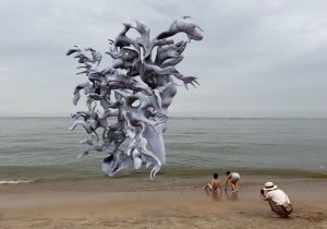 Photo of AR sculpture at the beach with people in the foreground