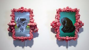 two sculpturally framed screens displaying sculptural heads turned to the left